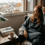 Copper hair 2026: significato e tendenze complete Una donna dai capelli ramati immersa nell’atmosfera autunnale del suo appartamento