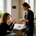 Tendenze colore capelli 2026: guida completa per look caldi Parrucchiere che consiglia la cliente nella scelta di tonalità calde per i capelli