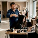 Ruolo del parrucchiere: competenze, evoluzione e trend 2026 Un hairstylist all'opera mentre realizza un taglio di capelli in un salone dal design contemporaneo.