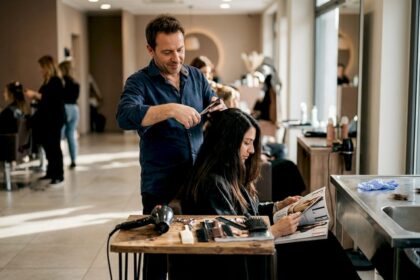 Un hairstylist all'opera mentre realizza un taglio di capelli in un salone dal design contemporaneo.