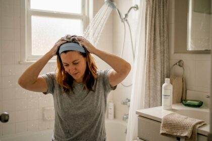 Donna che si prende cura dei suoi capelli colorati lavandoli delicatamente a casa