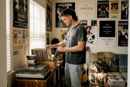 Un uomo con un taglio di capelli anni '80 sfoglia dischi in vinile in un negozio.